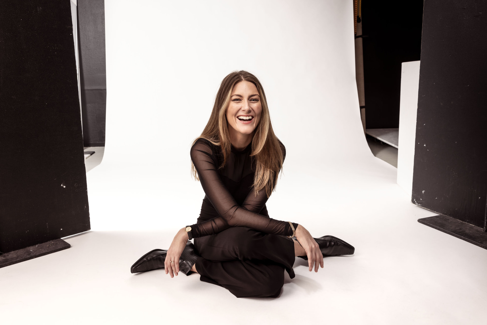 Ellinor Olmarken laughing, seated in the studio in black